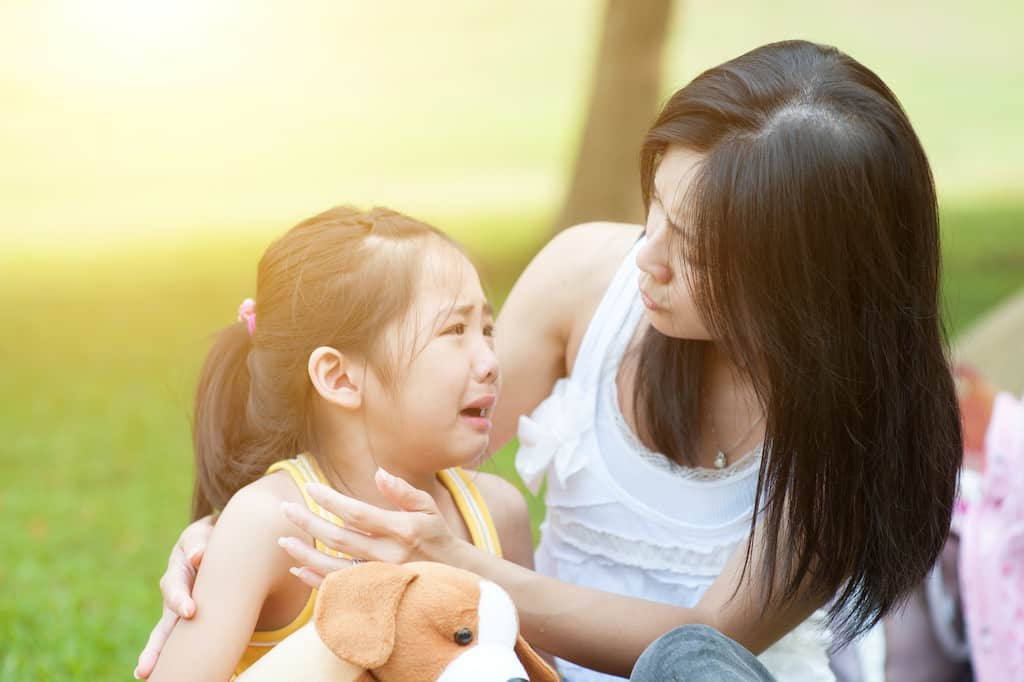 Mom comforting crying girl- How to stop sibling rivalry