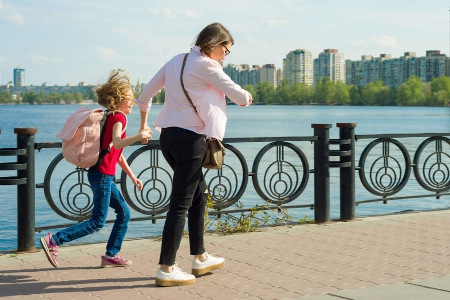 Mom hurrying daughter while going to school