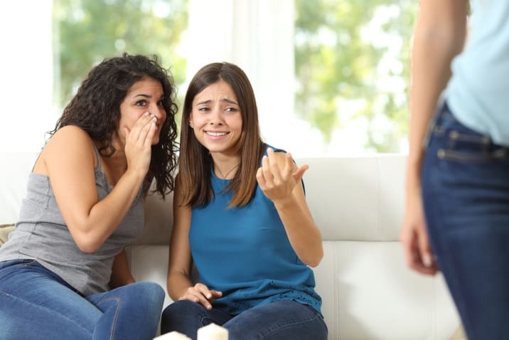 Two women gossiping about other woma. One of the bad habits of moms is judging other moms