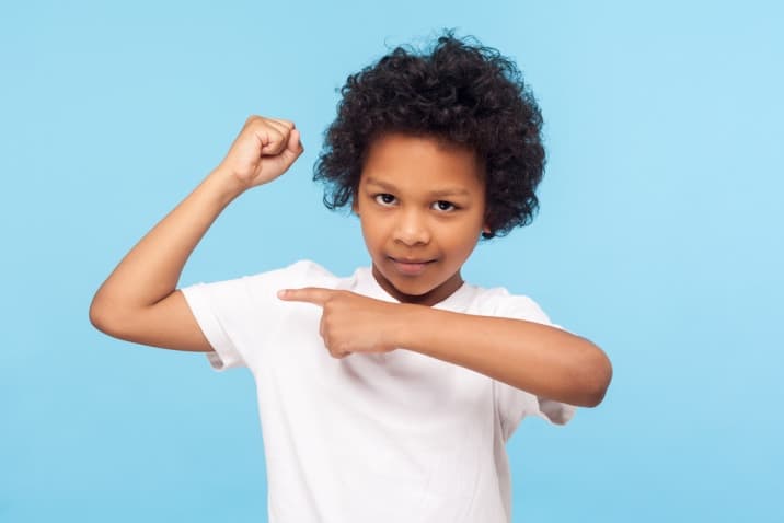 boy showing his muscle-hugging improves immunity