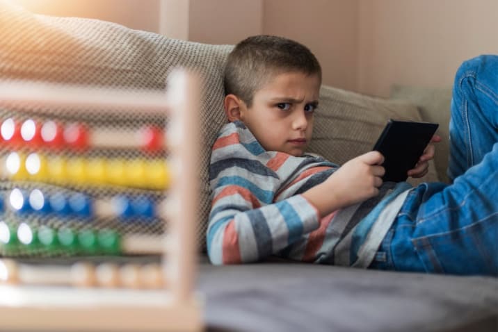 angry entitled child playing with tablet