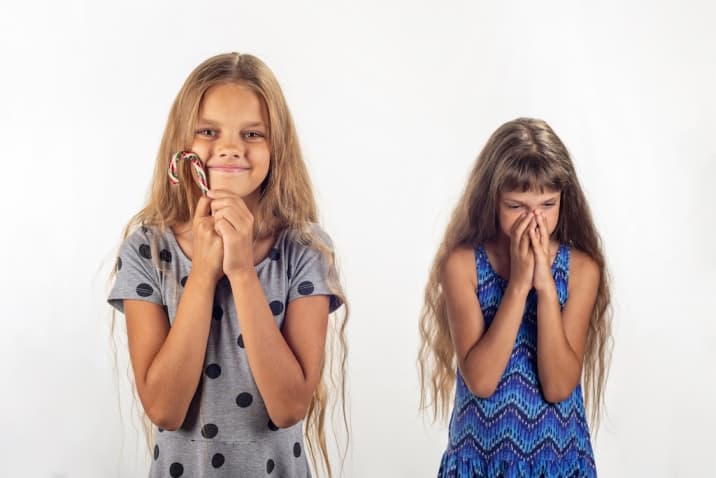 Girl not sharing her toy with her sister