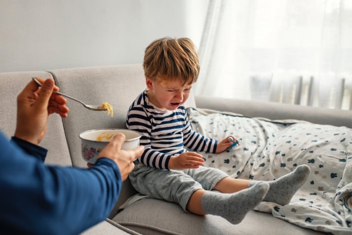 boy throwing a tantrum while eating food