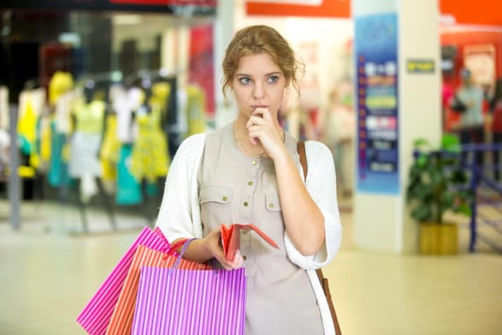 a woman thinking about a purchase - how to stop accumulating clutter