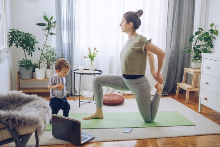  a mom doing yoga while kid is running around