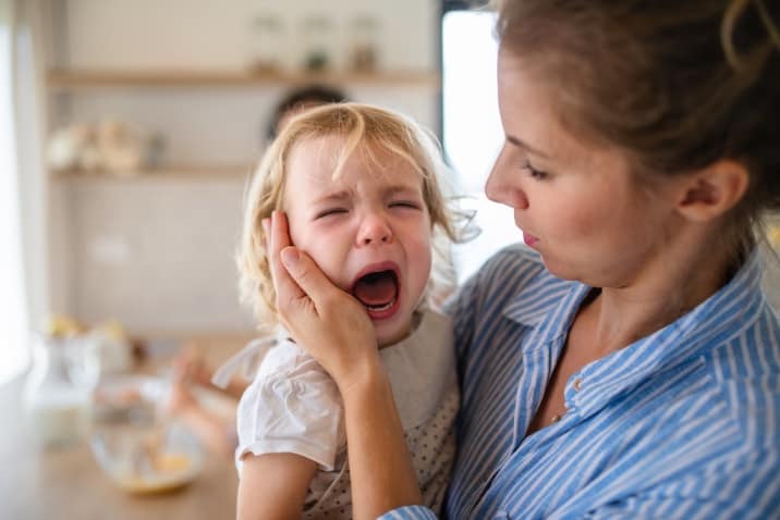 a mom consoling a crying toddler