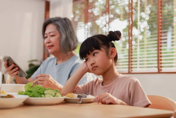 signs of bad parenting - a child ignored by parent during mealtime