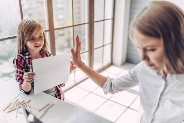 signs of bad parenting - a girl is ignored by her mom when she shows her artwork