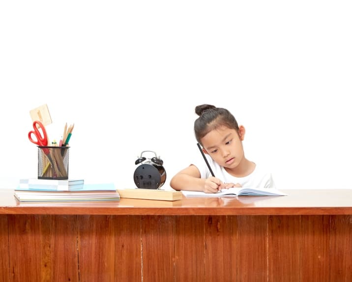 a girl doing homework at her study table