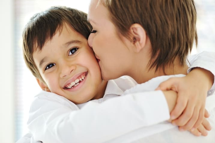 A mom hugging a child - type of positive reinforcement