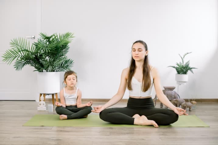 mom meditating with daughter