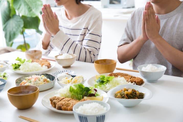 a family praying before eating meals-list of basic good manners for kids