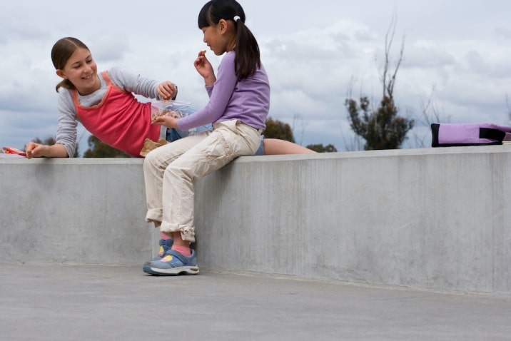 two girls sharing snacks with each other-list of basic good manners for kids