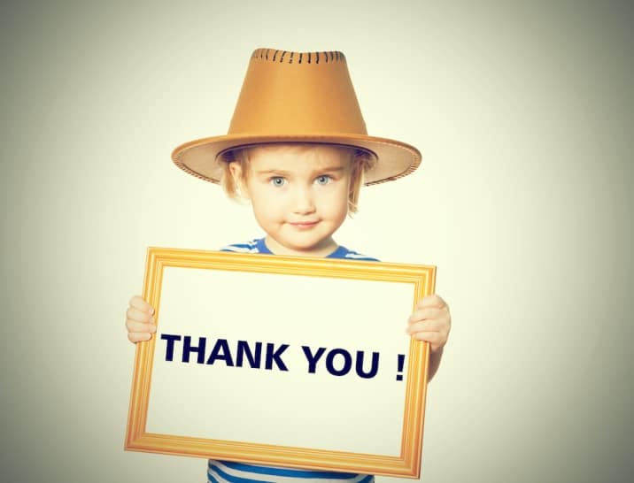 A child showing a banner saying 'thank you'-list of basic good manners for kids