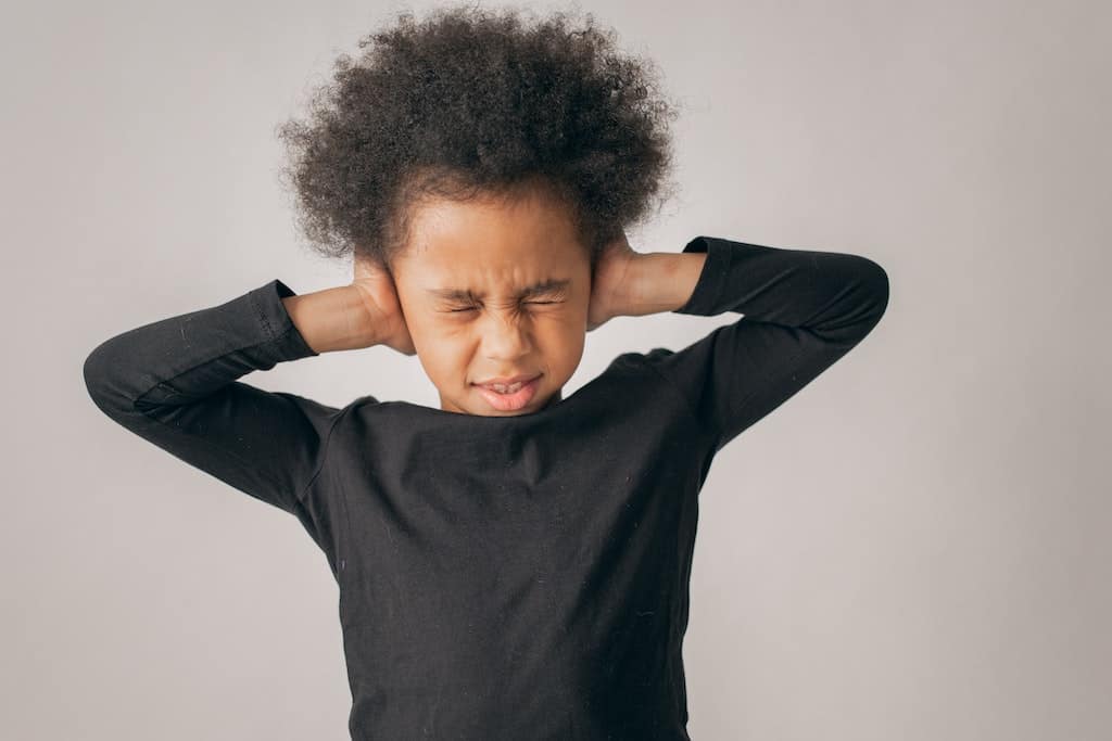 a child covering ears (signs of highly sensitive child)