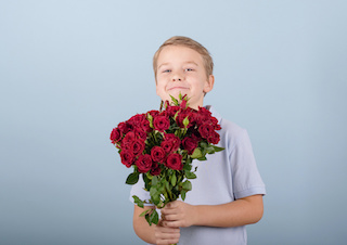 how to raise respectful kids - a boy holding a bouquet of flowers