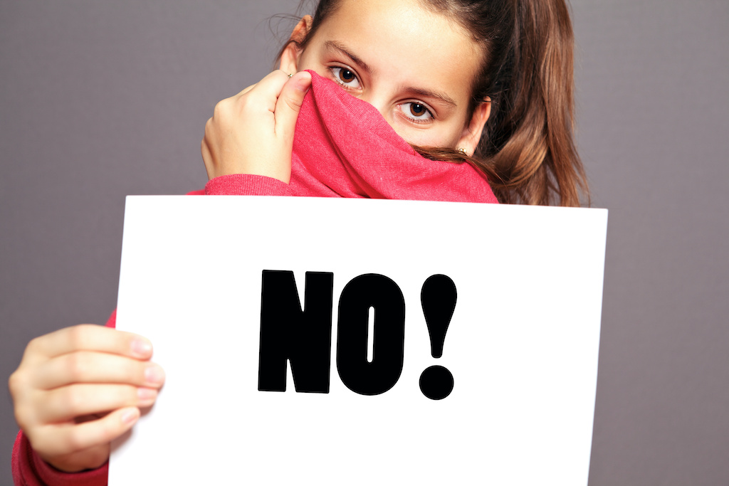  a girl holding a board showing NO - 5 body safety rules for kids