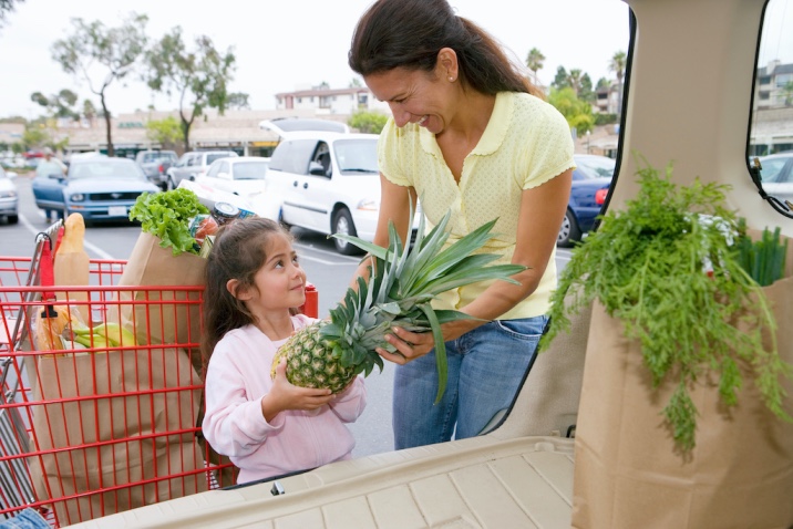 a girl handing a pineapple over to her mom - random acts of kindness idea - helping mom with groceries