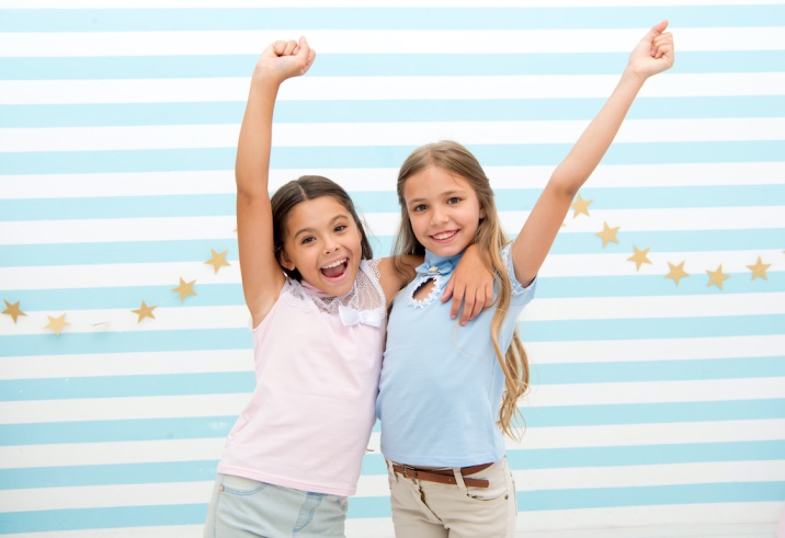 Two girls standing shoulder to shoulder