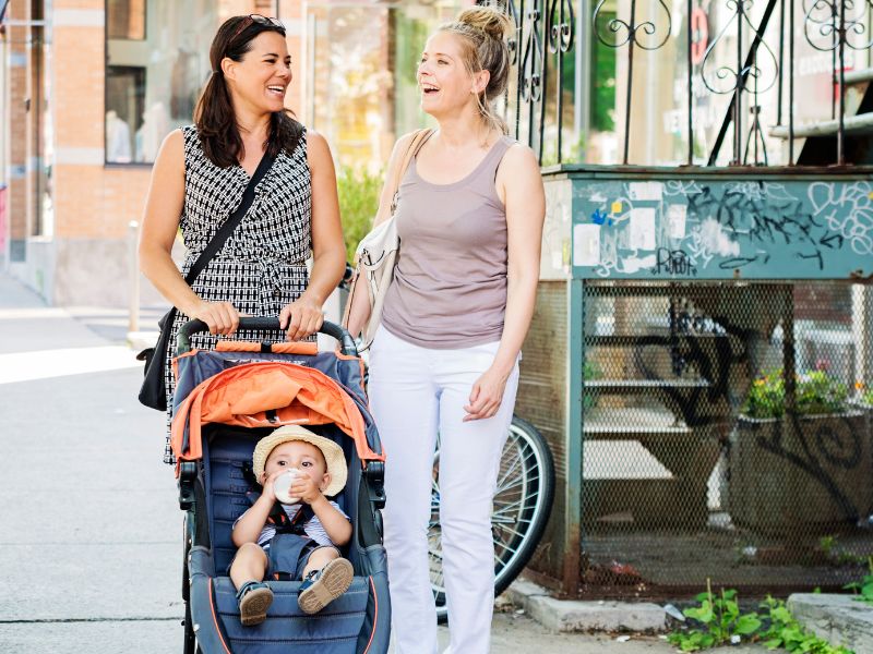 a mom with a stroller talking with her friend