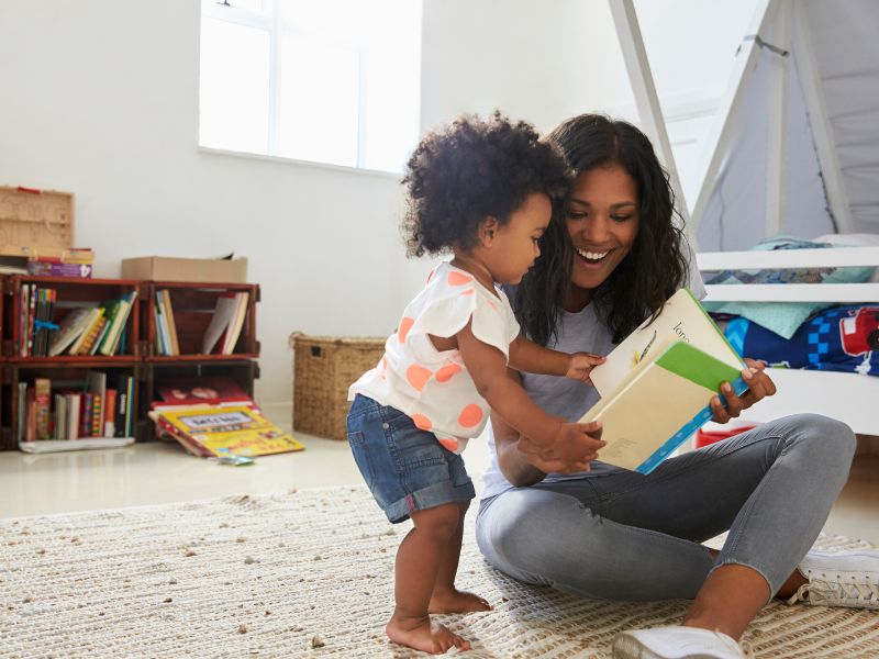 Mother reading a board book to a toddler