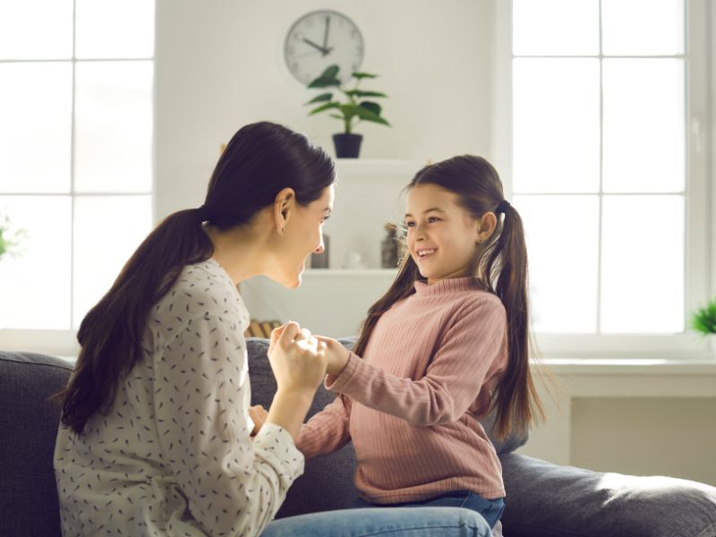 a mom talking with a girl happily
