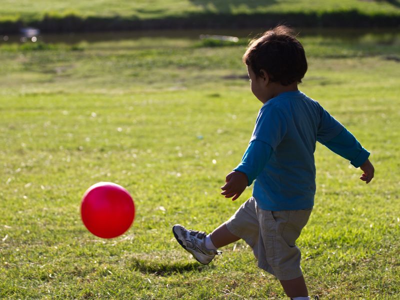 a toddler playing soccer with a balloon - easy and fun balloon games for toddlers and preschoolers