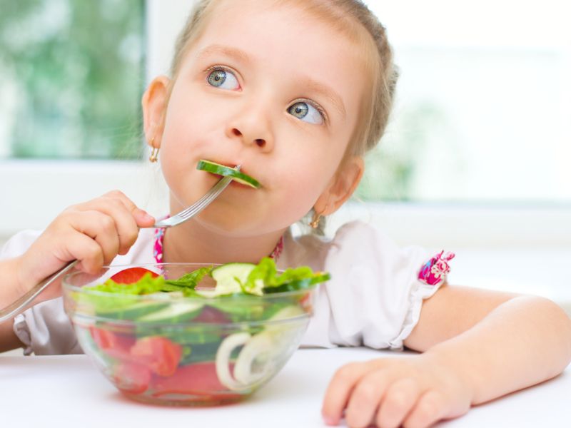 a girl eating salad - establishing a bedtime routine for kids