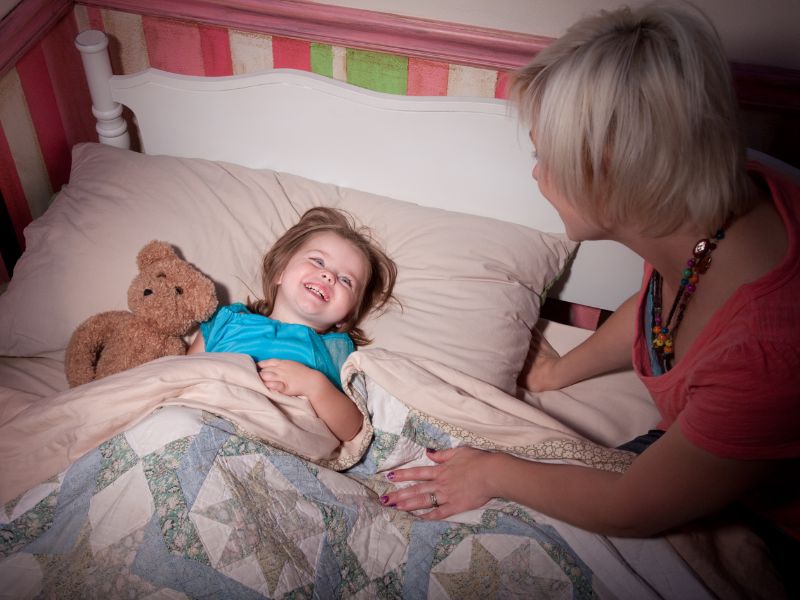 a mom putting toddler to bed - establishing a bedtime routine for kids