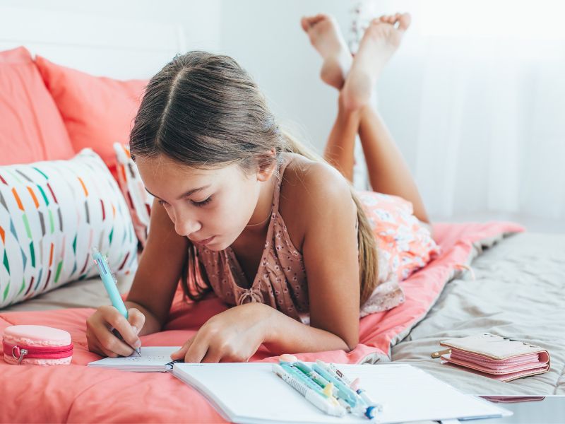 a girl journling - calm down activities for kids to wind down before sleep