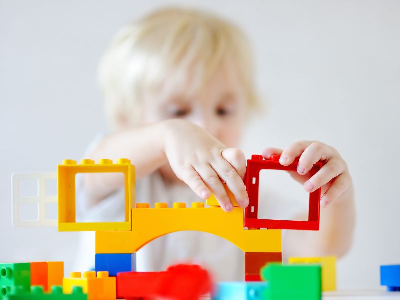 a toddler playing with blocks - calm down activities for kids to wind down before sleep