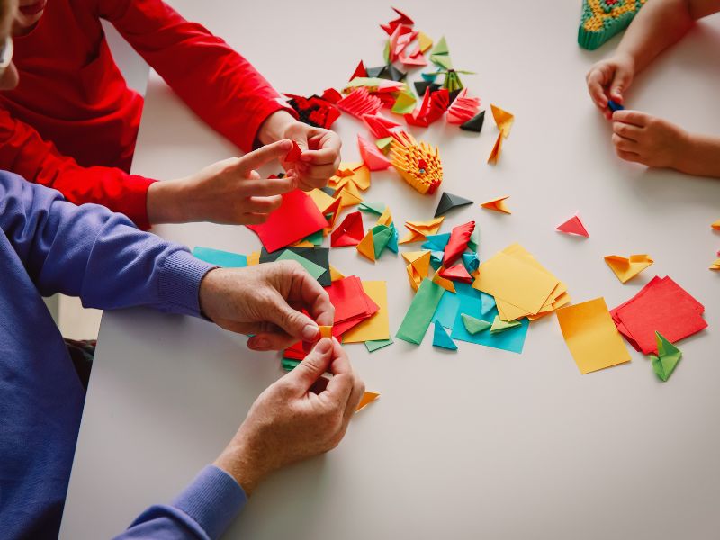 a family doing origami - calm down activities for kids to wind down before sleep