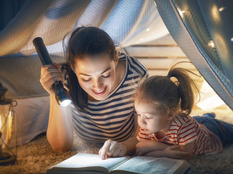 a mom reading bedtime story to daughter - calm down activities for kids to wind down before sleep